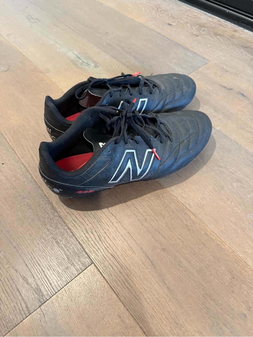 11Wide New Balance Men’s Black Athletic Soccer Shoes with Red Accents